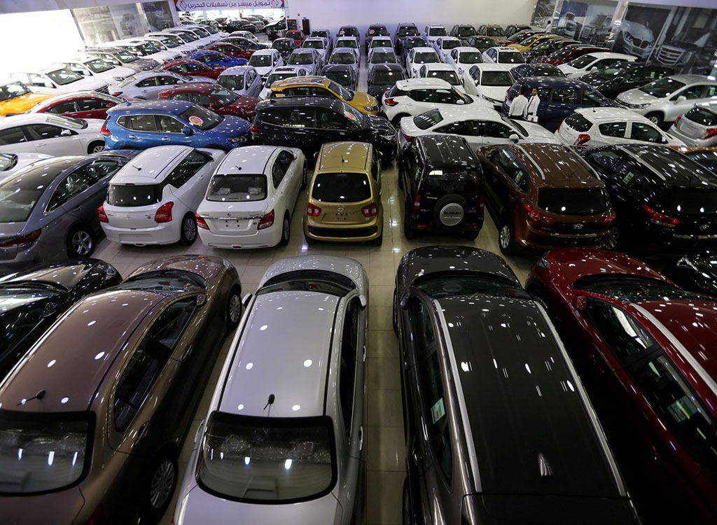 FILE PHOTO: Auto dealers stand between the cars displayed for sa